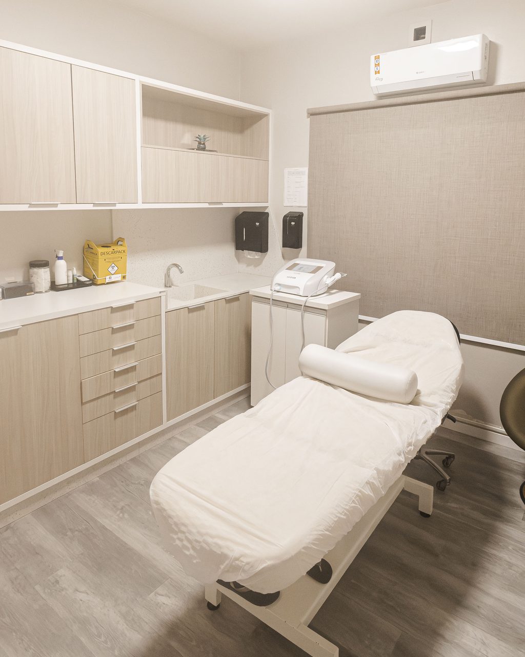 Sala de procedimentos da Corpo & Forma, com maca clínica preparada e bancada de apoio